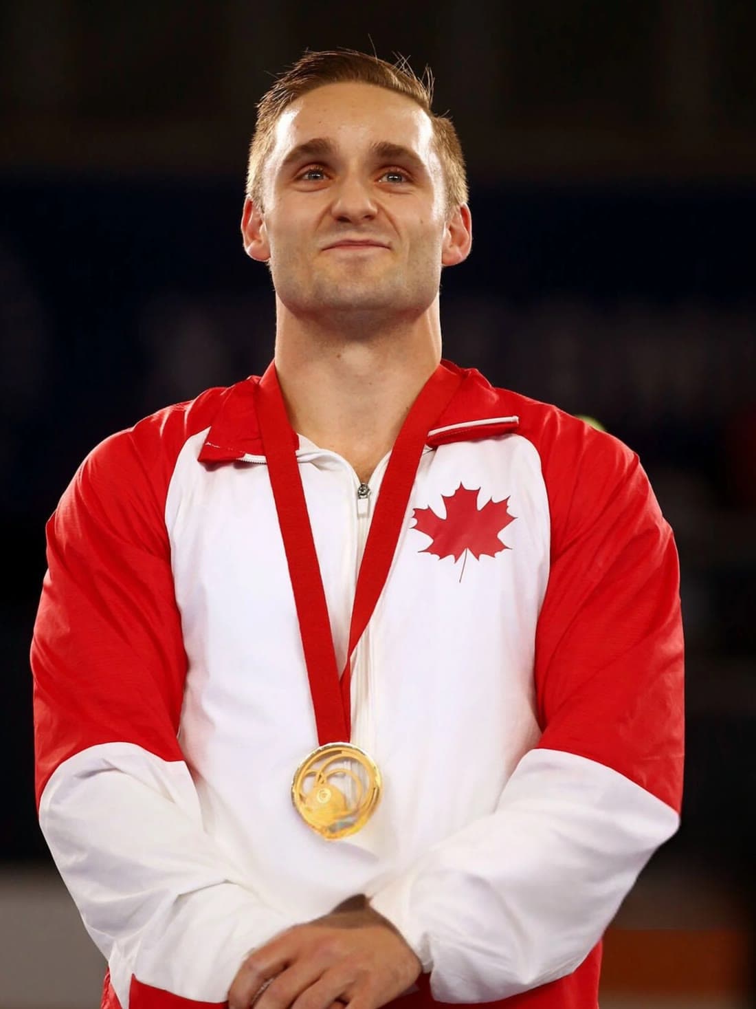 In Team Canada colours at a medal ceremony, a medal around his neck.